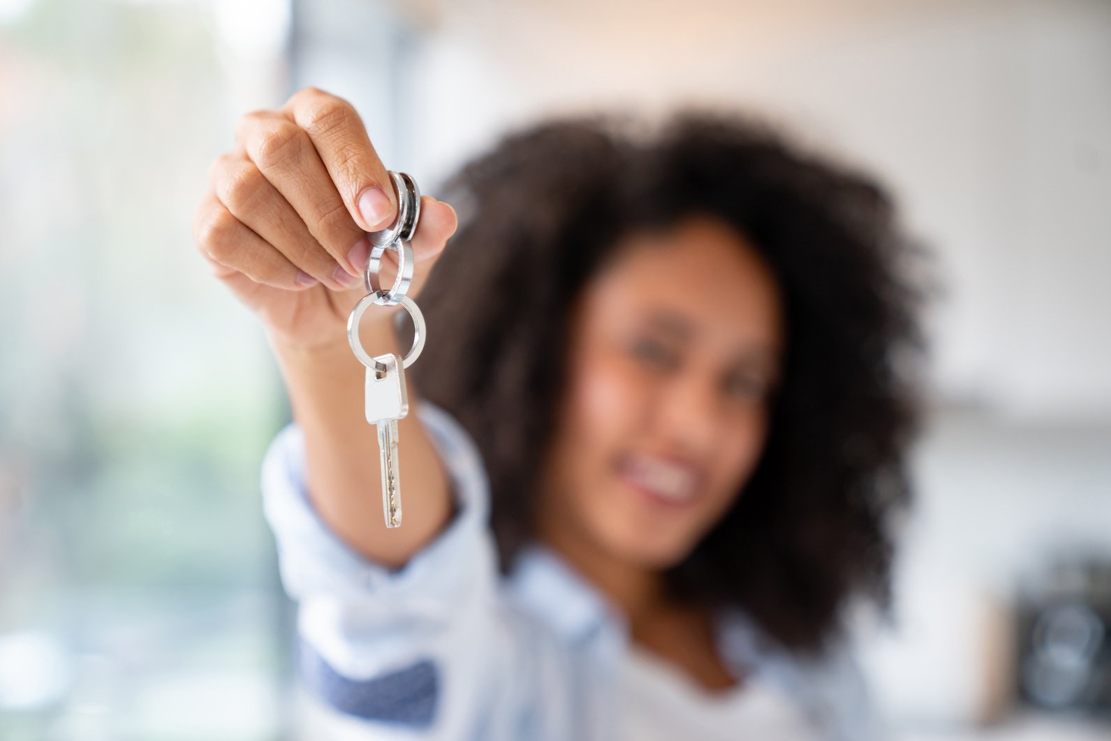 Happy home owner holding the keys to her house